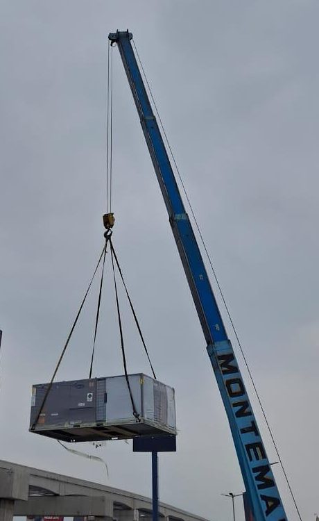 Grúa elevando equipo de aire acondicionado tipo paquete de 25 TR