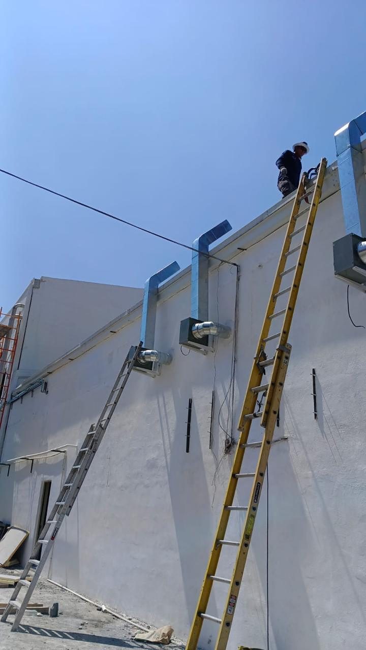 Técnico de SEGA instalando ductos de extracción en muro de planta de alimentos